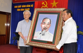 Tổng Bí thư Nguyễn Phú Trọng tặng bức tranh chân dung Bác Hồ cùng lời nhắn gửi: Đảng bộ, chính quyền và nhân dân Bình Phước cố gắng học và làm theo gương Bác. Ảnh Trần Phương