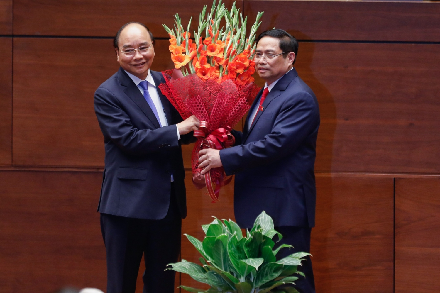 Chủ tịch nước Nguyễn Xuân Phúc tặng hoa chúc mừng Thủ tướng Phạm Minh Chính. Ảnh: VGP/Nhật Bắc