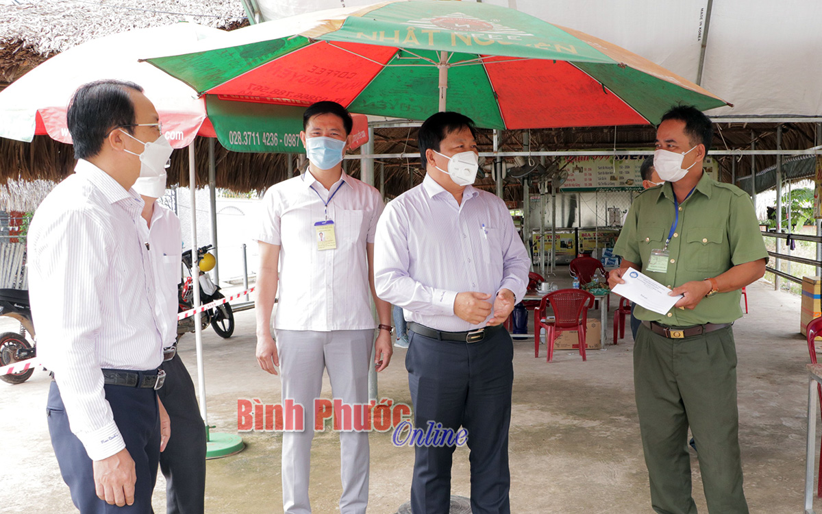 Phó chủ tịch UBND tỉnh Trần Văn Mi trao quà động viên lực lượng trực chốt kiểm soát dịch Covid-19 của TP. Đồng Xoài trên ĐT741, xã Tiến Hưng