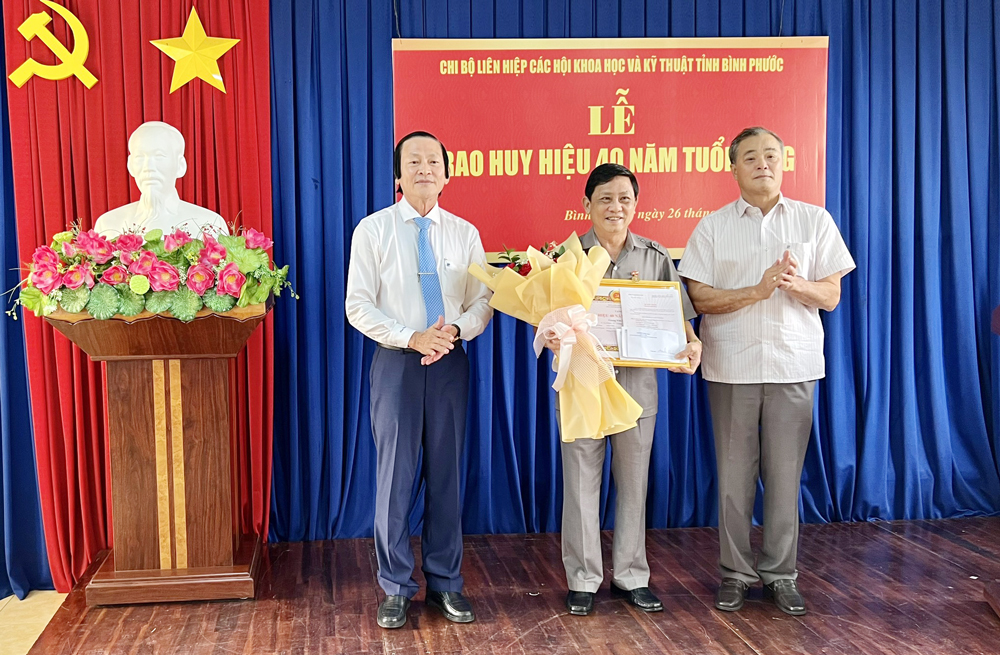 Thay mặt Thường trực Tỉnh ủy, Đồng chí Nguyễn Hồng Trà - Ủy viên Ban Thường vụ, Trưởng Ban Tổ chức Tỉnh ủy và đồng chí Nguyễn Phúc Hậu - Tỉnh ủy viên, Bí thư Đảng ủy Khối cơ quan và Doanh nghiệp trao Huy hiệu 40 năm tuổi Đảng cho đồng chí Giang Văn Khoa